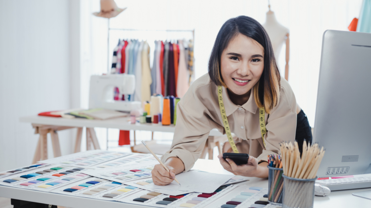 Designer are thinking and designing clothes for customers order items at the designer desk in the studio. Clothes designers are working in the office.