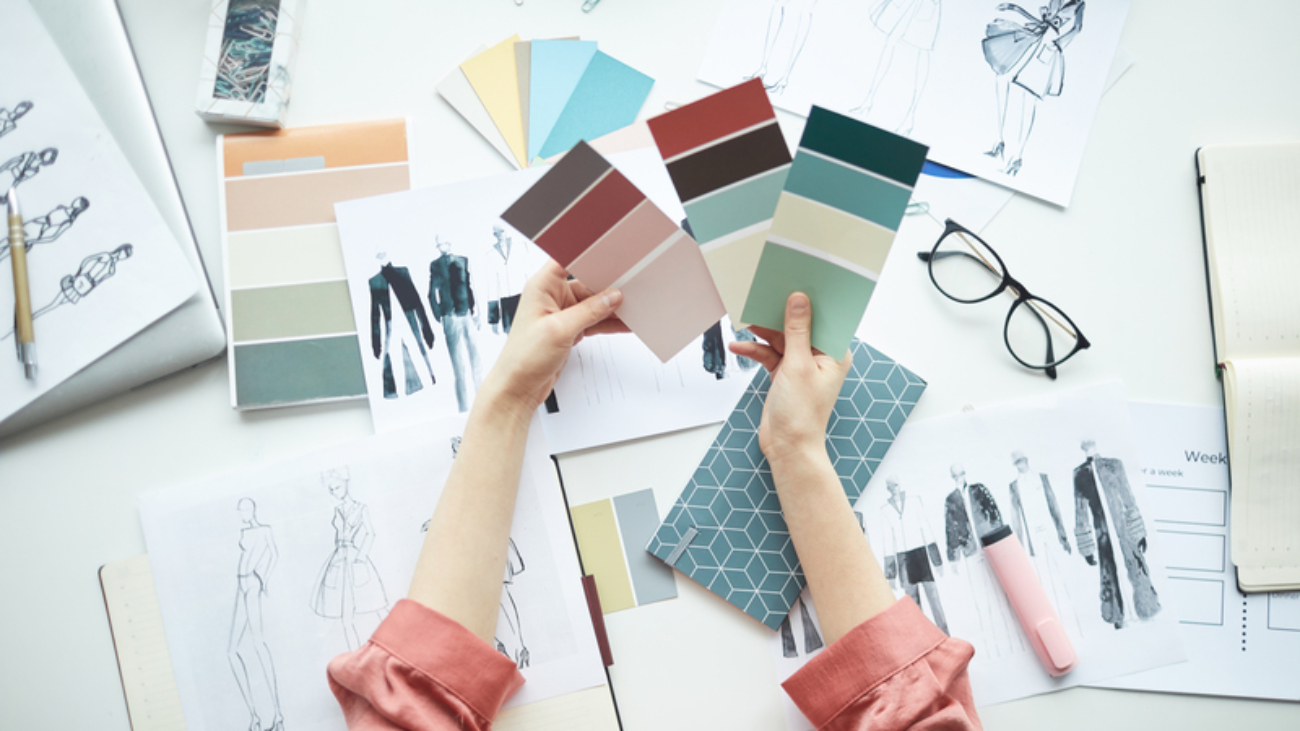 Close-up of businesswoman holding colored palette and choosing a color at her workplace at office